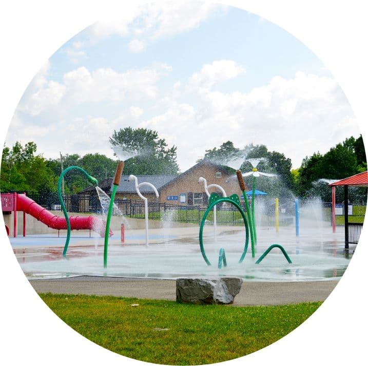 Splash pad with water play structures and a playground slide