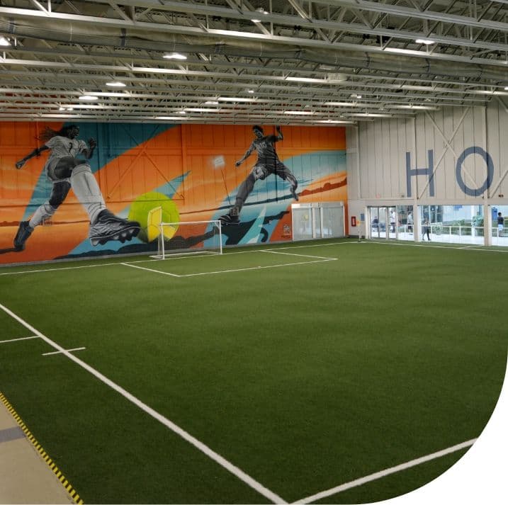 Indoor turf field with a sports mural